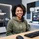 A diverse person smiling confidently in a modern, bright office environment.